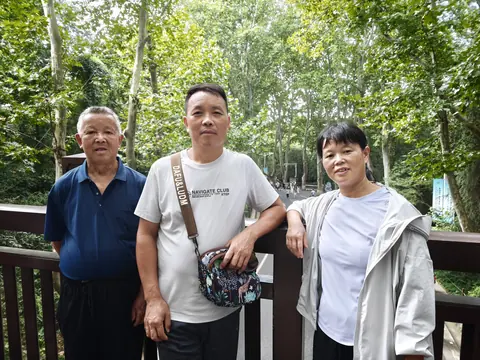 家人在绿荫下留下的旅行合影